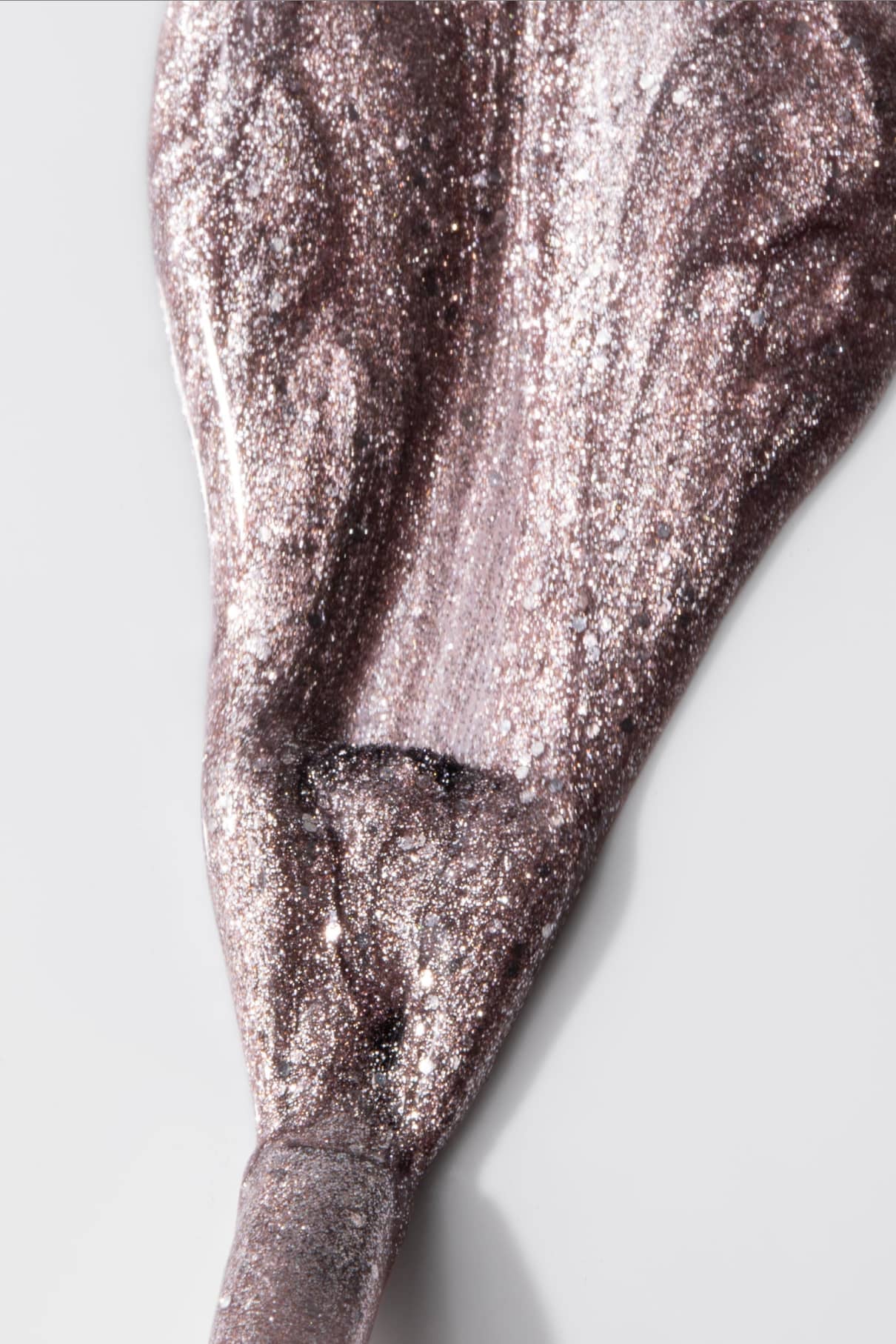 Gitti no. Der Nagellack 215 in metallischem Silber und schimmerndem Rosé-Mauve wird in einem dicken, strukturierten Streifen auf eine weiße Oberfläche aufgetragen.