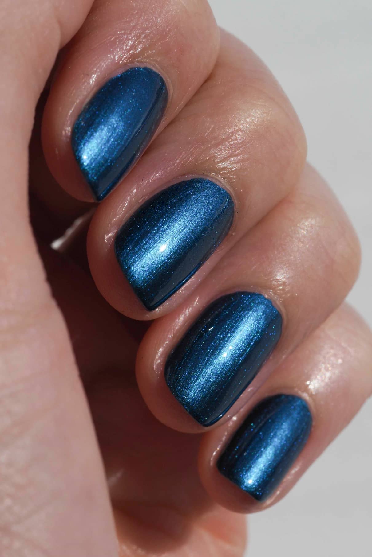 Eine Nahaufnahme einer Hand mit kurzen, sauber manikürten Nägeln, die mit dem auffälligen Nagellack gitti no. 304 Nagellack lackiert sind.