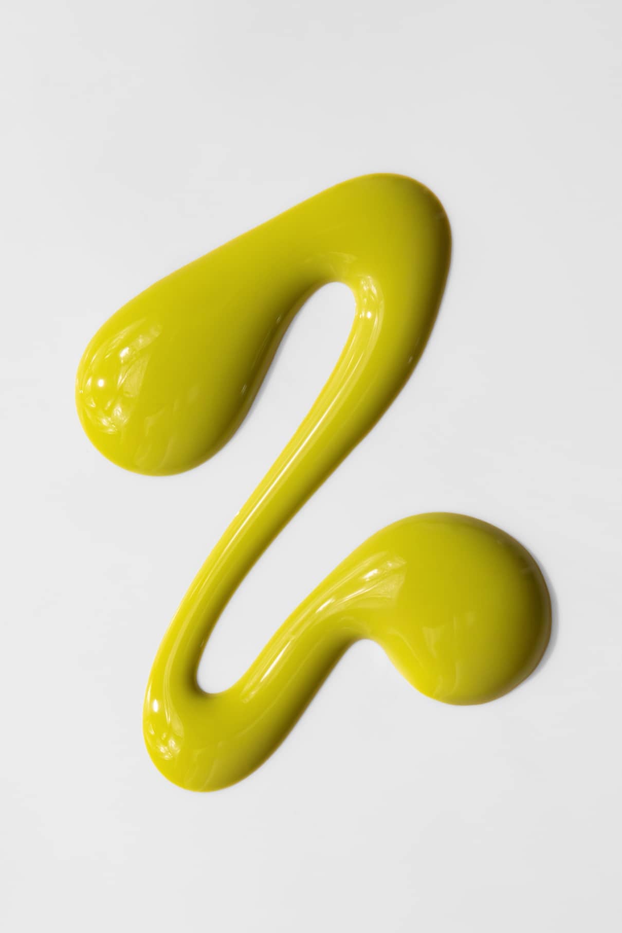 Ein geschwungener, gelber Farbstrich von gitti no. 05+ mit gelber Unterton auf weißem Grund, der an einen losen, stilisierten Buchstaben Z oder die Zahl 2 erinnert.