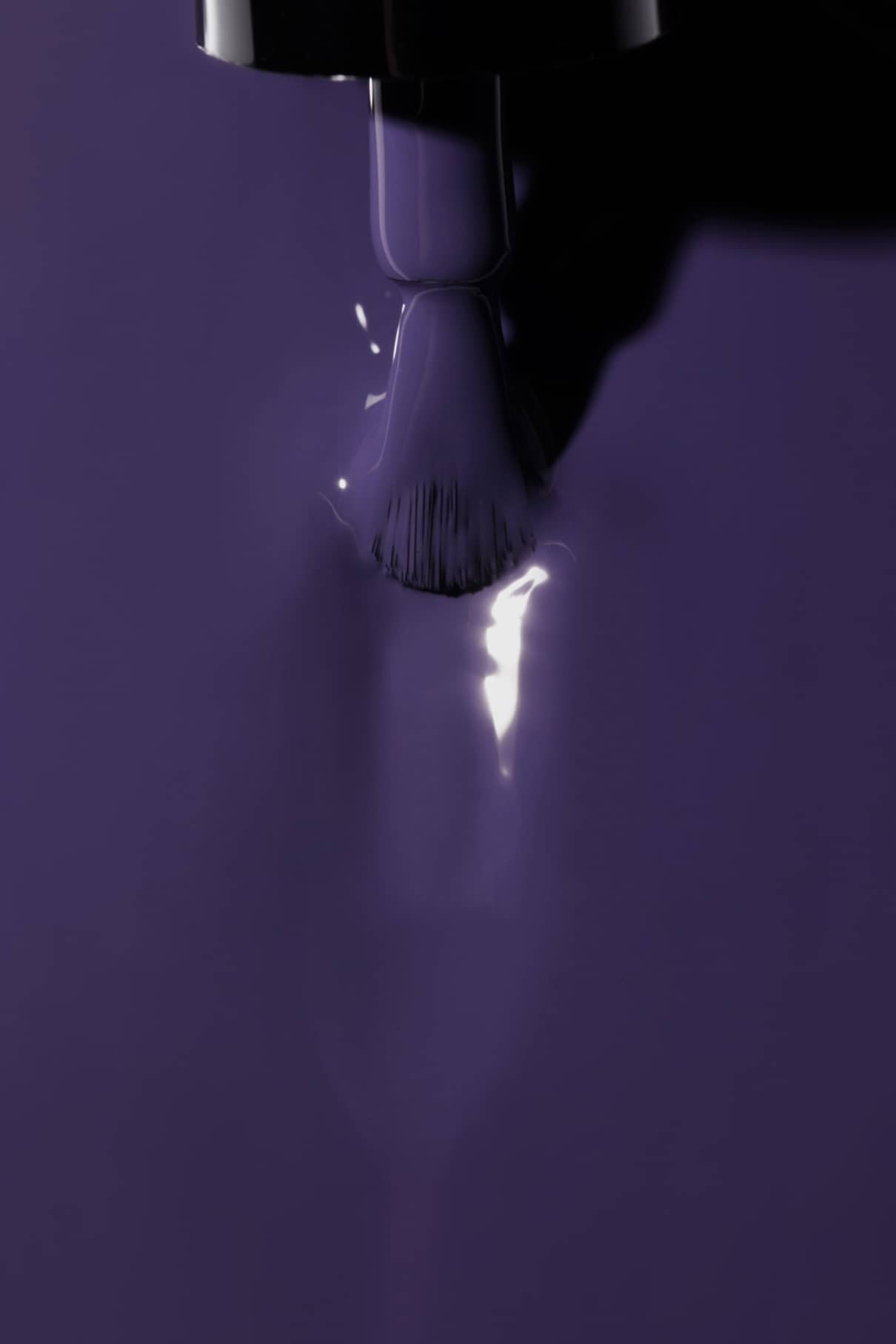 Mit einem Pinsel überzieht gitti no. 07+ überzieht die Nägel mit einem glänzenden violetten Lack mit lilafarbenem Unterton und hinterlässt eine glatte Oberfläche und einen reflektierenden Glanz in der frischen Schicht.