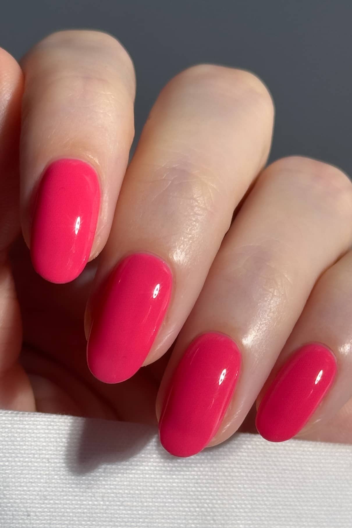 Die Nahaufnahme einer Hand mit vier Fingern zeigt sauber manikürte Nägel, die in gitti no. 08+, einem leuchtenden Rosaton mit glänzendem Finish.