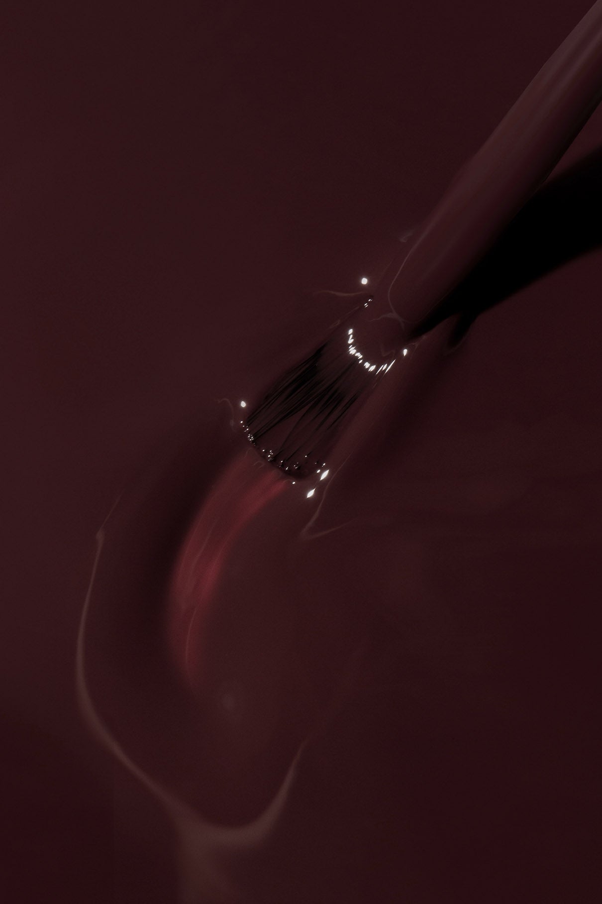 Eine Nahaufnahme eines Pinsels, mit dem gitti no. 183 Nagellack aufzutragen, wobei glänzende Reflexe auf der farbenprächtigen Oberfläche sichtbar werden.