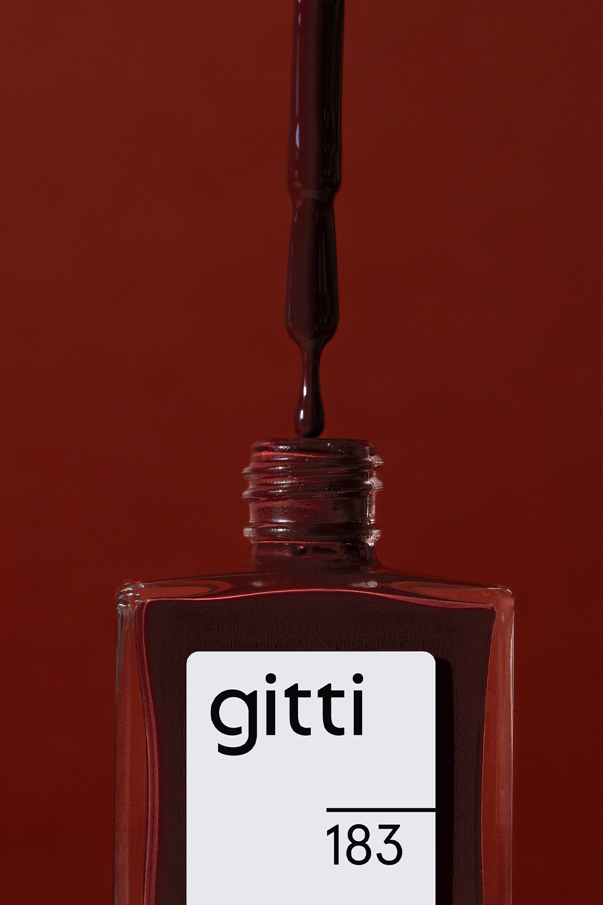 Ein Tropfer mit gitti no. 183, ein tiefbeerroter Nagellack, schwebt über einer offenen quadratischen Flasche mit der Aufschrift gitti no. 183 vor einem roten Hintergrund.