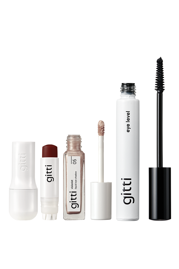 Vier gitti-Produkte aus dem Lash, Lip & Cheek Trio in einer Reihe: ein weißer Stift, ein dunkelroter Lip Sync Case Balm, ein nudefarbener flüssiger Lipgloss mit Zauberstab und schwarze Mascara in der Set-Tube.