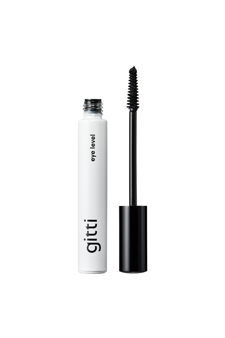 Eine weiße Tube Eye Level Mascara steht aufrecht mit offenem Deckel und schwarzem Applikator - ideal für einen natürlichen Look.