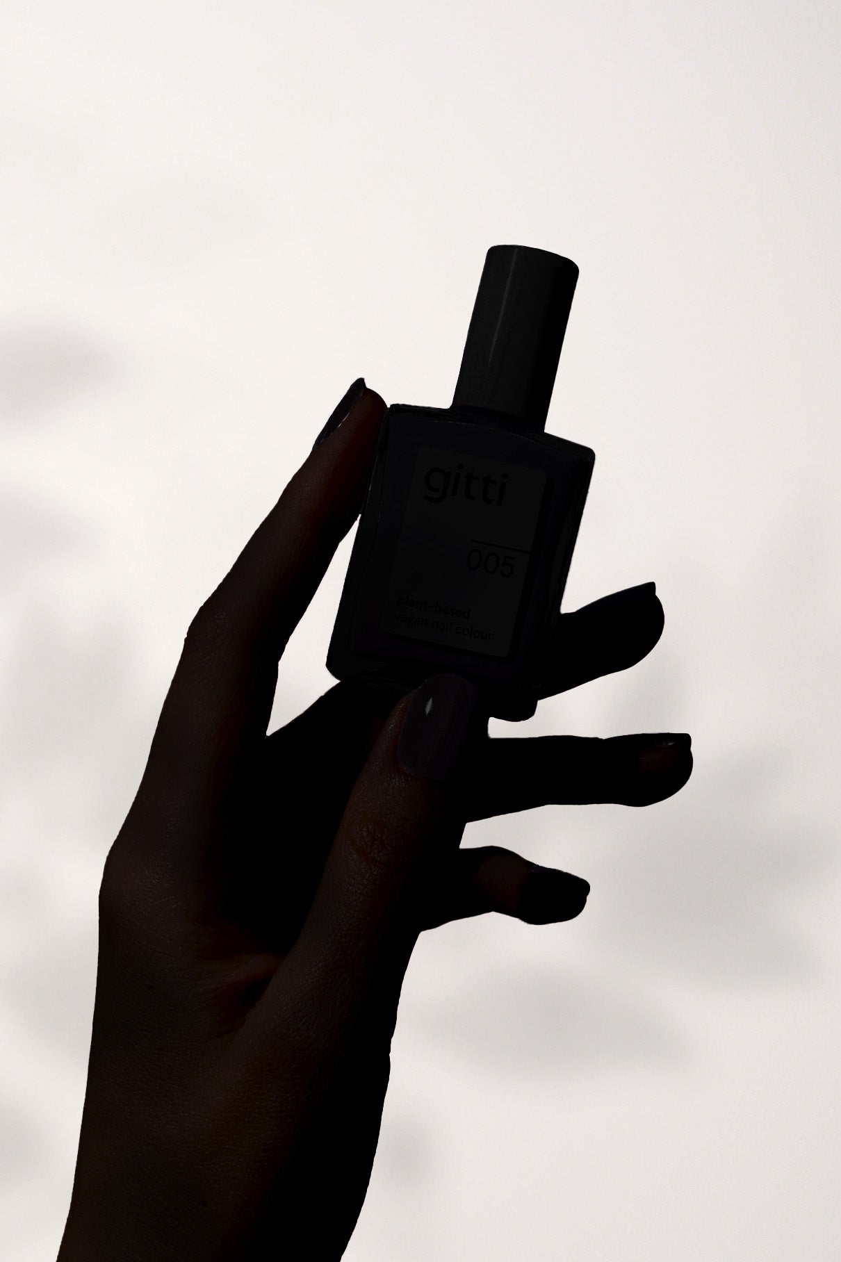 Eine Silhouette einer Hand, die eine rechteckige Flasche mit der Aufschrift Mystery Box vor einem hellen Hintergrund hält.