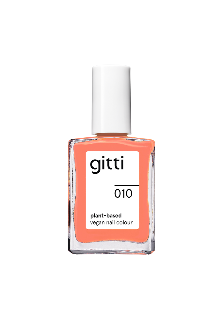 Der gitti no. 010 pflanzlicher veganer Nagellack kommt in einer Klarglasflasche mit weißer Kappe, schwarzem Textetikett und bietet eine intensivere Nuancierung im Korallton.