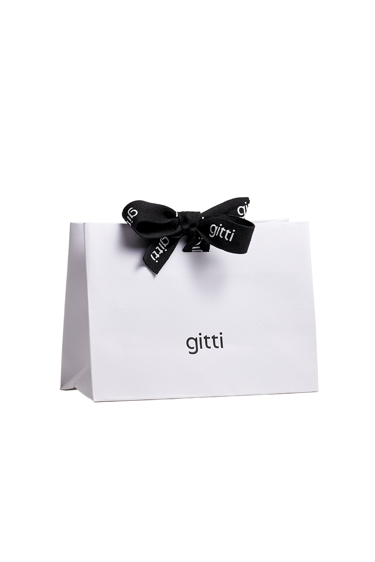 Eine weiße Geschenktüte mit dem Aufdruck "gitti", verziert mit einer eleganten schwarzen Schleife.