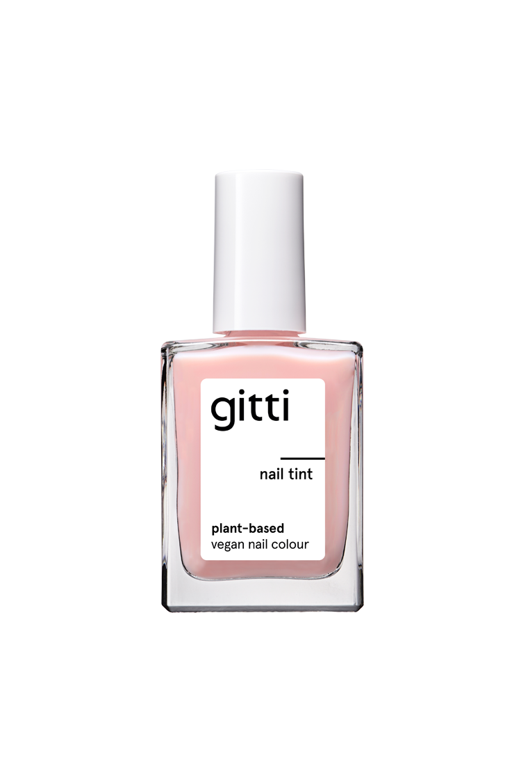 Eine Klarglasflasche Nail Tint mit weißem Verschluss. Auf dem Etikett steht pflanzliche, vegane Nagelfarbe. Im Inneren befindet sich ein zarter, milchig-hellrosa Lack ("milchiger zartrosa Ton") für einen subtilen und eleganten Look.