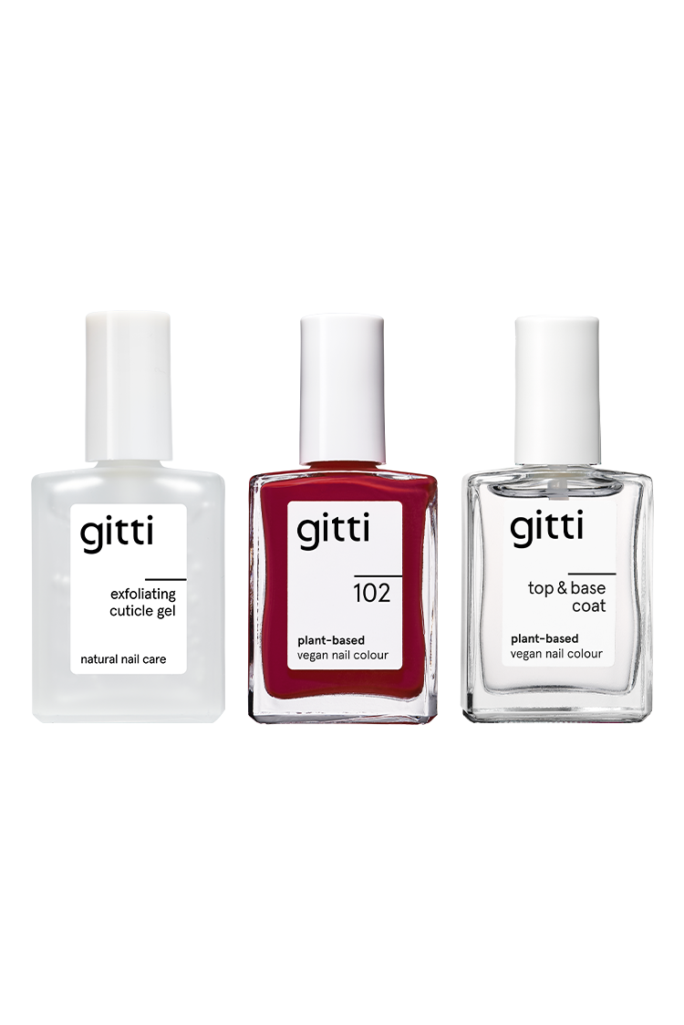 Das Essential Manicure Set enthält drei aufrecht stehende Flaschen mit eleganten weißen Kappen: Peeling-Häutchen-Gel, vegane Nagelfarbe auf Pflanzenbasis im Farbton 102 und einen Top & Base Coat.