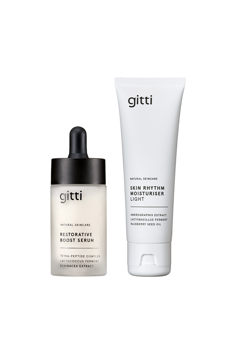 Das Restore + Hydrate Duo von gitti besteht aus einer mattierten Glastropfflasche mit Restorative Boost Serum und einer weißen Tube mit Skin Rhythm Moisturiser Light, die beide für unterschiedliche Pflegebedürfnisse konzipiert sind.