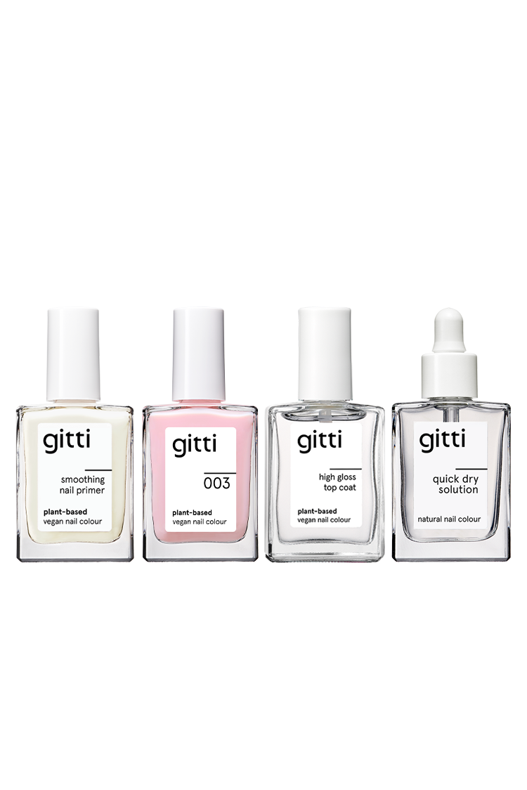 Die Quick Dry Routine von Gitti besteht aus vier durchsichtigen Glasflaschen - dem Smoothing Nail Primer, der veganen Nagelfarbe 003, dem High Gloss Top Coat und der Quick Dry Solution - die kunstvoll in einer Reihe angeordnet sind.