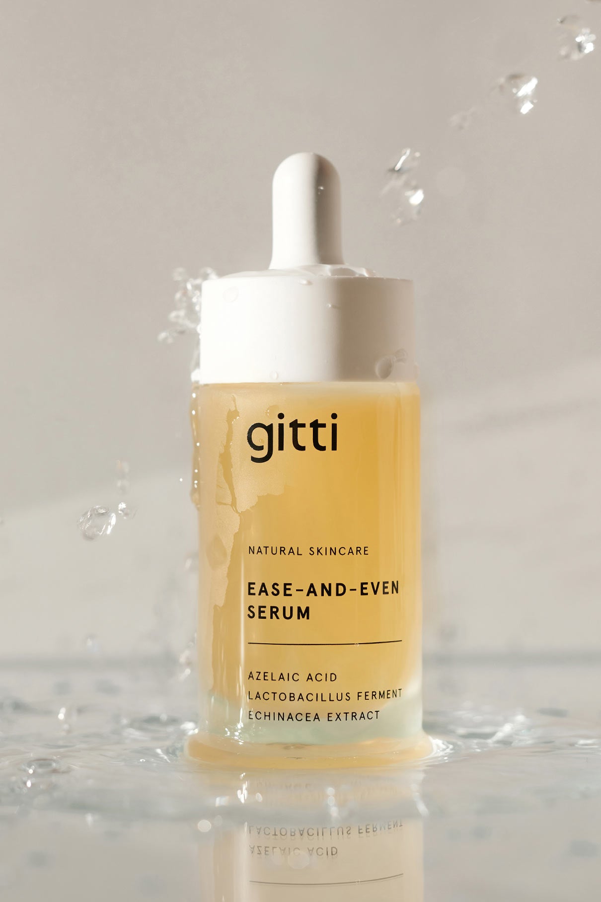 Eine Flasche des Ease-and-Even-Serums mit Tropfverschluss, umgeben von Wasserspritzern. Das Etikett hebt Azelainsäure, Lactobacillus-Ferment und Echinacea-Extrakt hervor - ideal für eine ausgeglichene Ölproduktion und eine klarere Haut.