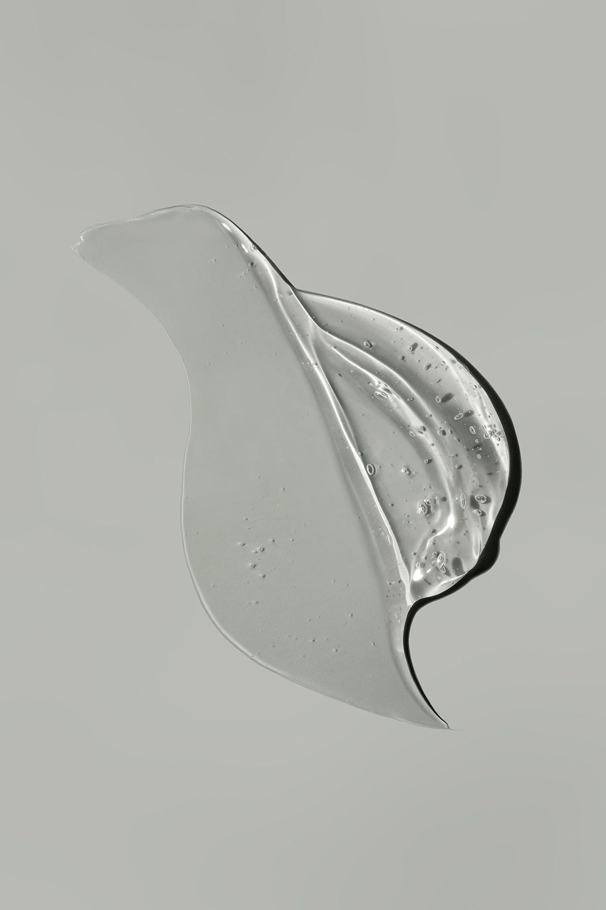 Sanftes Gen C Gel mit kleinen Bläschen, geschwungen auf hellgrauem Hintergrund - inspiriert von der effektiven Reinigung eines Öl-Cleansers.