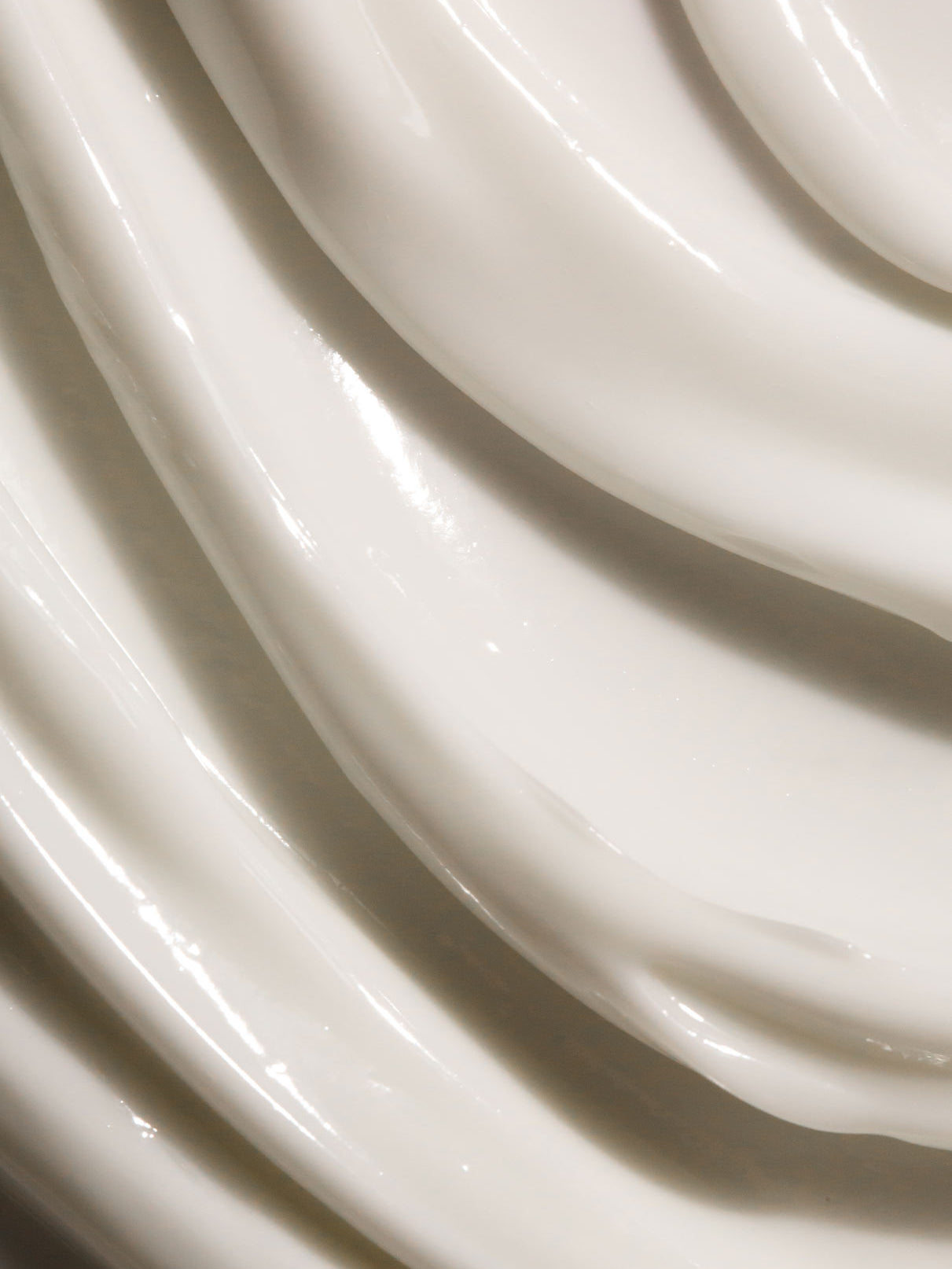 Nahaufnahme von Skin Rhythm Moisturiser Rich: glatte, weiße Creme mit dicken, glänzenden Wellen und strukturierten Rillen, die intensive Feuchtigkeit spendet und für ein gesundes Strahlen sorgt.