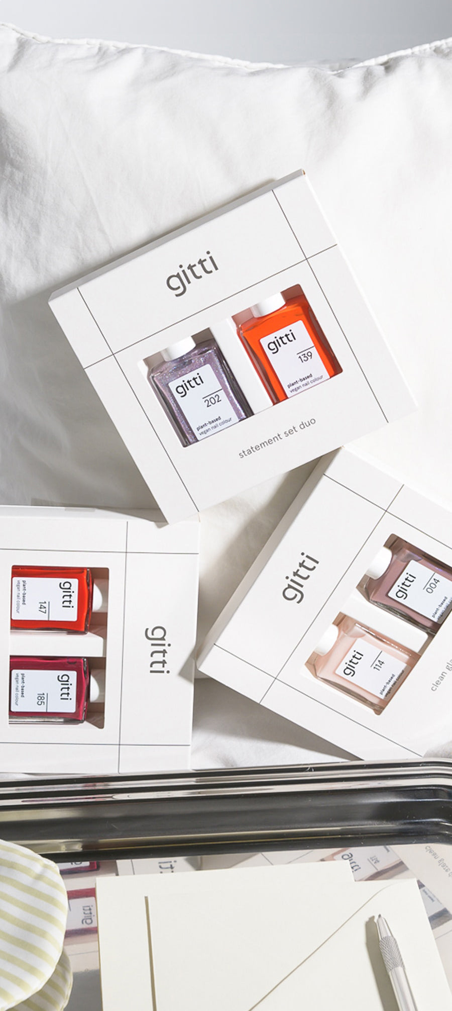 Drei pflanzenbasierte Duo-Geschenksets von gitti vor einem weißen Kissen 