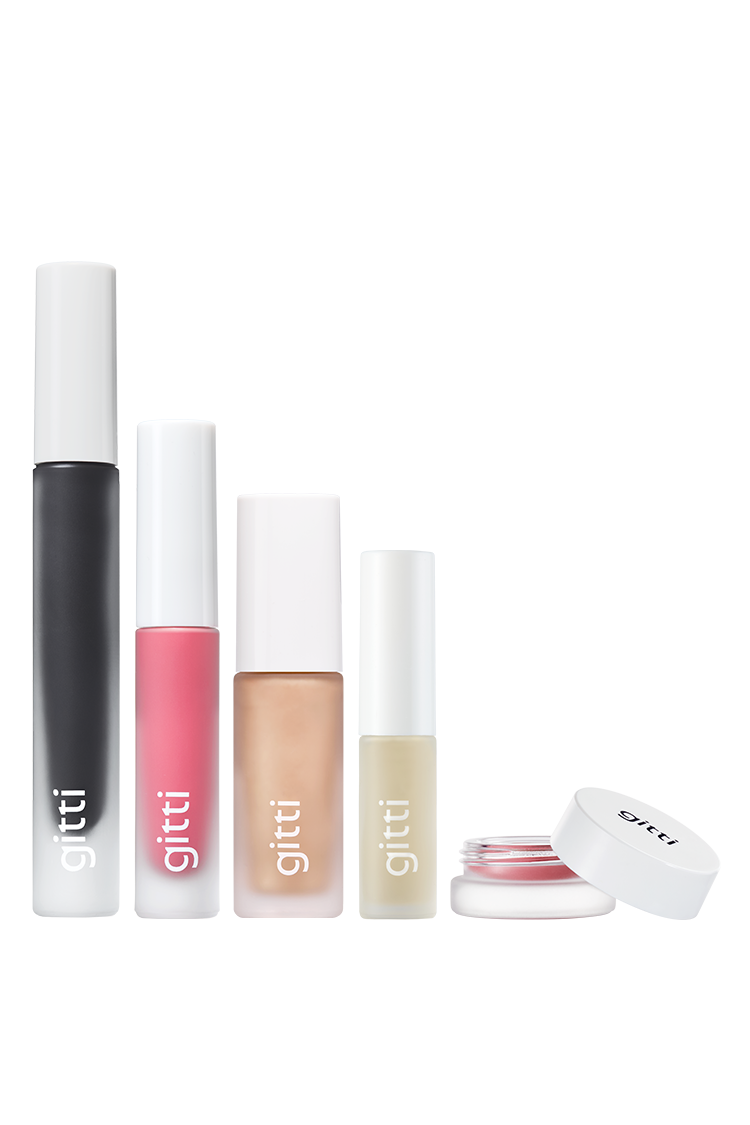 Das gitti beauty Signature Set mit fünf Produkten, darunter Velvet Cheeks, Lip Glaze Tuben und ein kleines Mascara-Döschen mit Schraubverschluss, steht aufrecht in einer Reihe auf weißem Hintergrund.