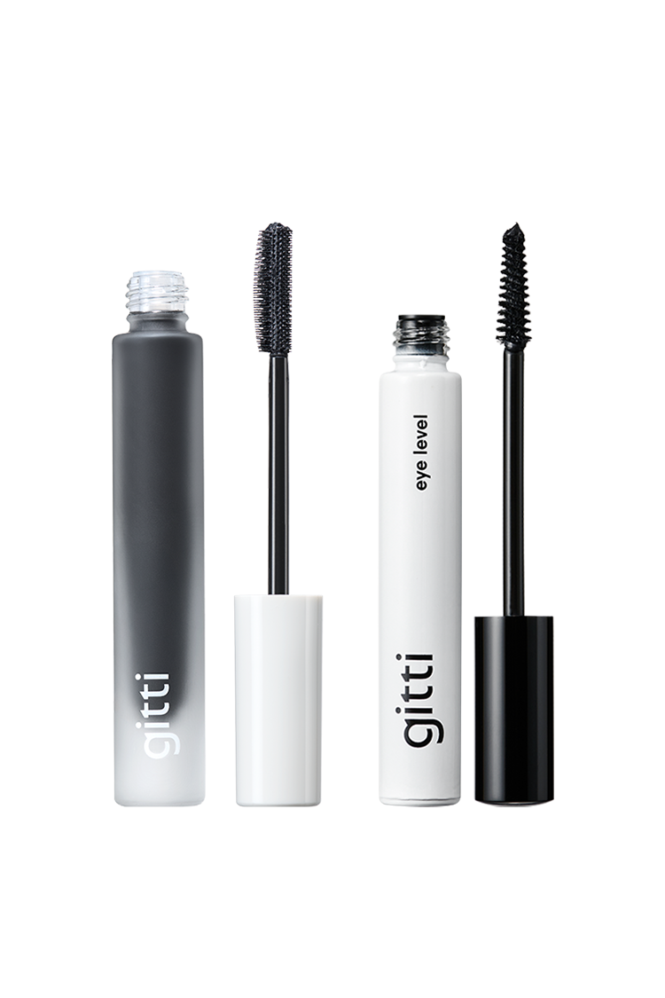 Zwei geöffnete Tuben des Lash Duo in einer eleganten schwarz-weißen Verpackung mit sichtbaren Mascarastäbchen vor einem klaren weißen Hintergrund.