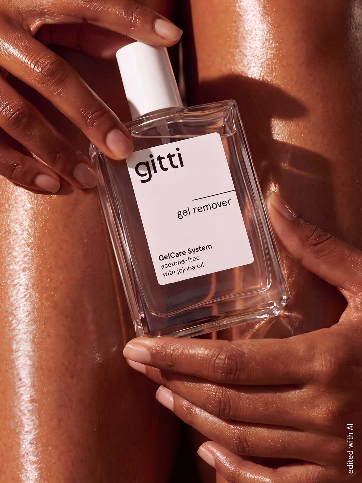 Hände, die eine rechteckige Flasche GelCare Remover mit Jojobaöl halten.