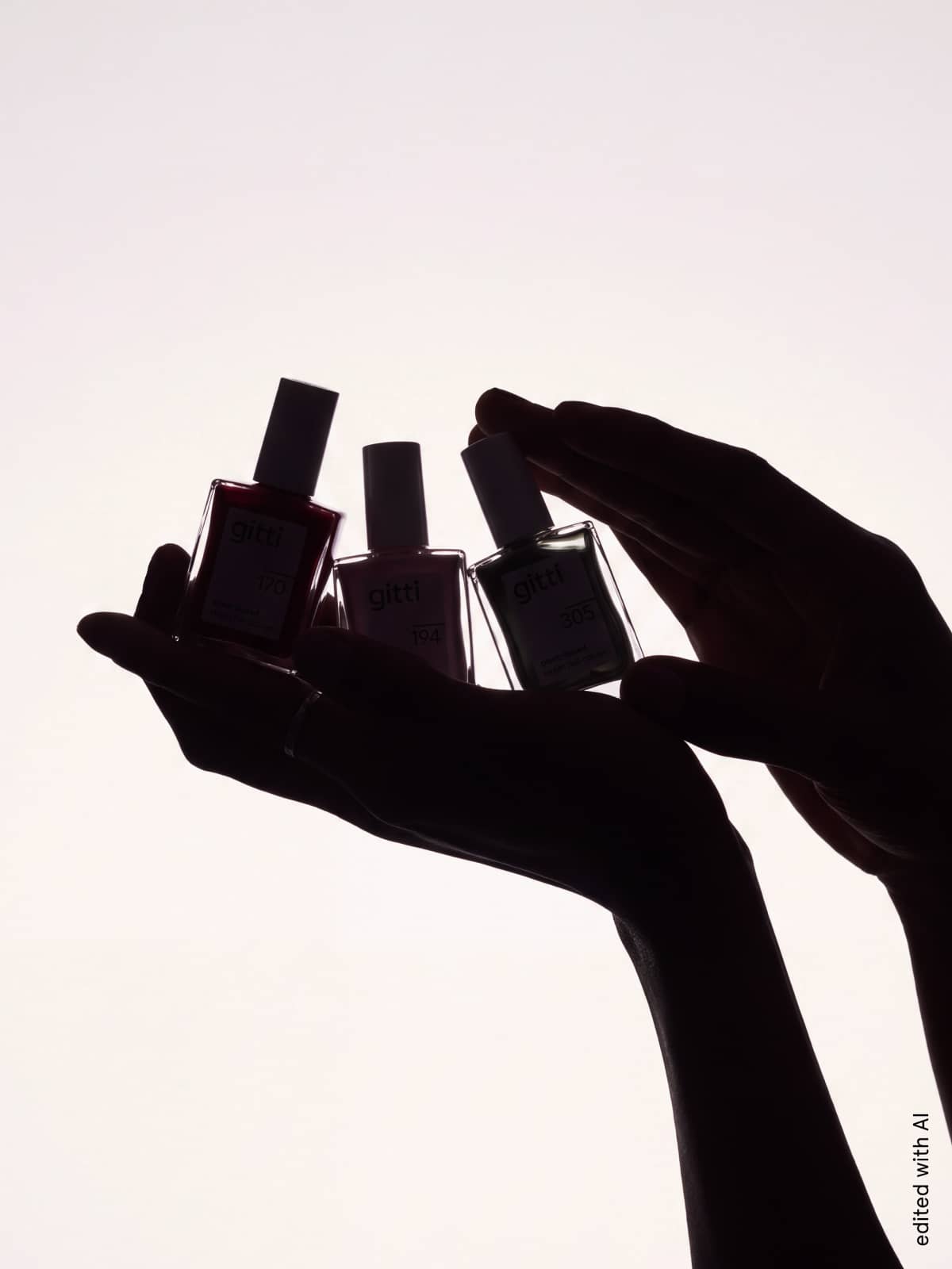 Vor einem weißen Hintergrund sind die Umrisse von Händen zu sehen, die drei Nagellackfläschchen mit der Aufschrift „gitti“ halten – ein Bild, das die Spannung beim Öffnen der Mystery Box und ihrer exklusiven Nagel- und Make-up-Produkte einfängt.