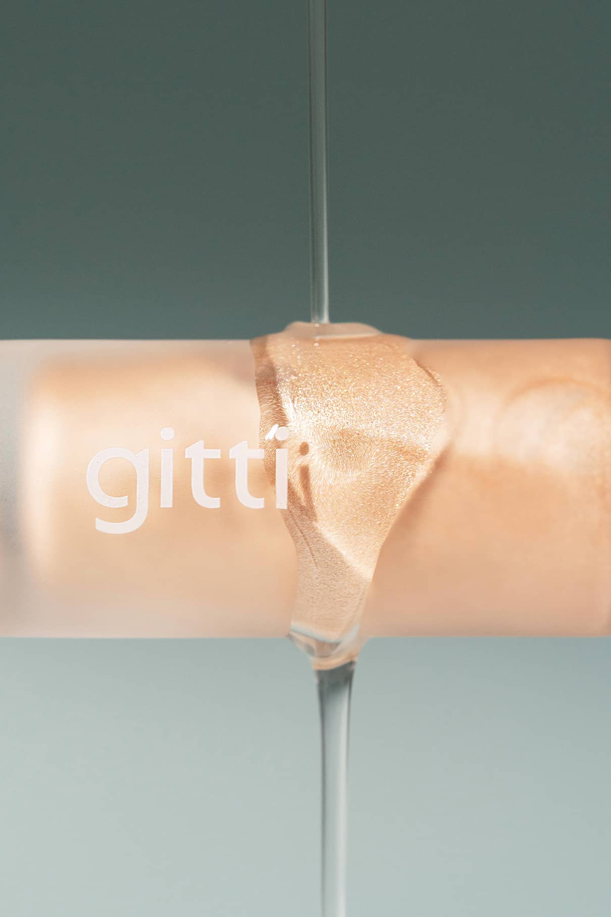 Nahaufnahme einer Milchglasflasche mit der Aufschrift gitti, die eine schimmernde beigefarbene Flüssigkeit aus dem Fresh Up Set enthält, über die eine klare Flüssigkeit gegossen wird.
