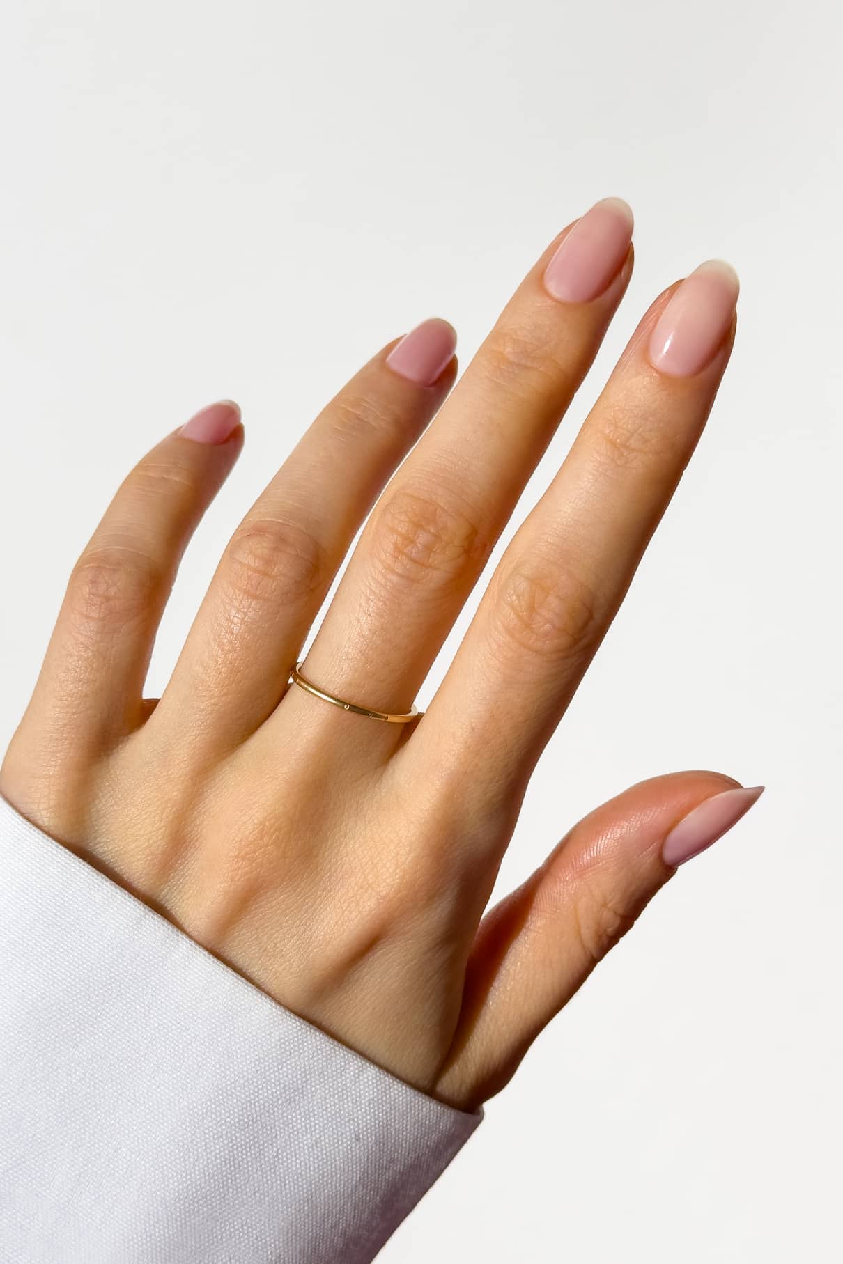 Eine Hand mit sauber manikürten hellrosa Nägeln trägt den Makaro Pontey Ring am Ringfinger, der sich vor einem schlichten weißen Hintergrund abhebt.