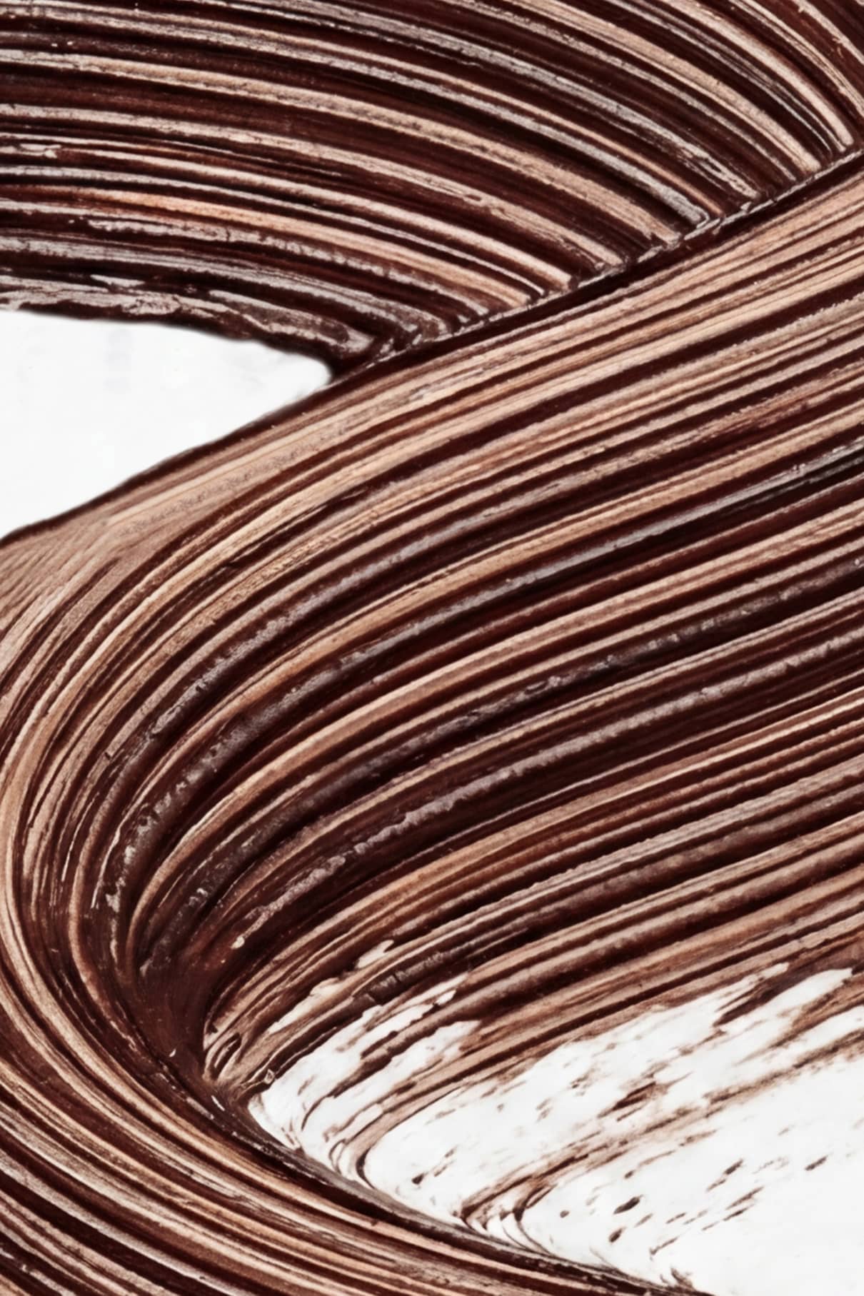 Nahaufnahme der dicken Infinite Lash Nr. 02 Mascara, die in geschwungenen, übereinanderliegenden Linien auf weißem Hintergrund sanft verwirbelt - ideal für alle, die Definition und ein luxuriöses Finish suchen.