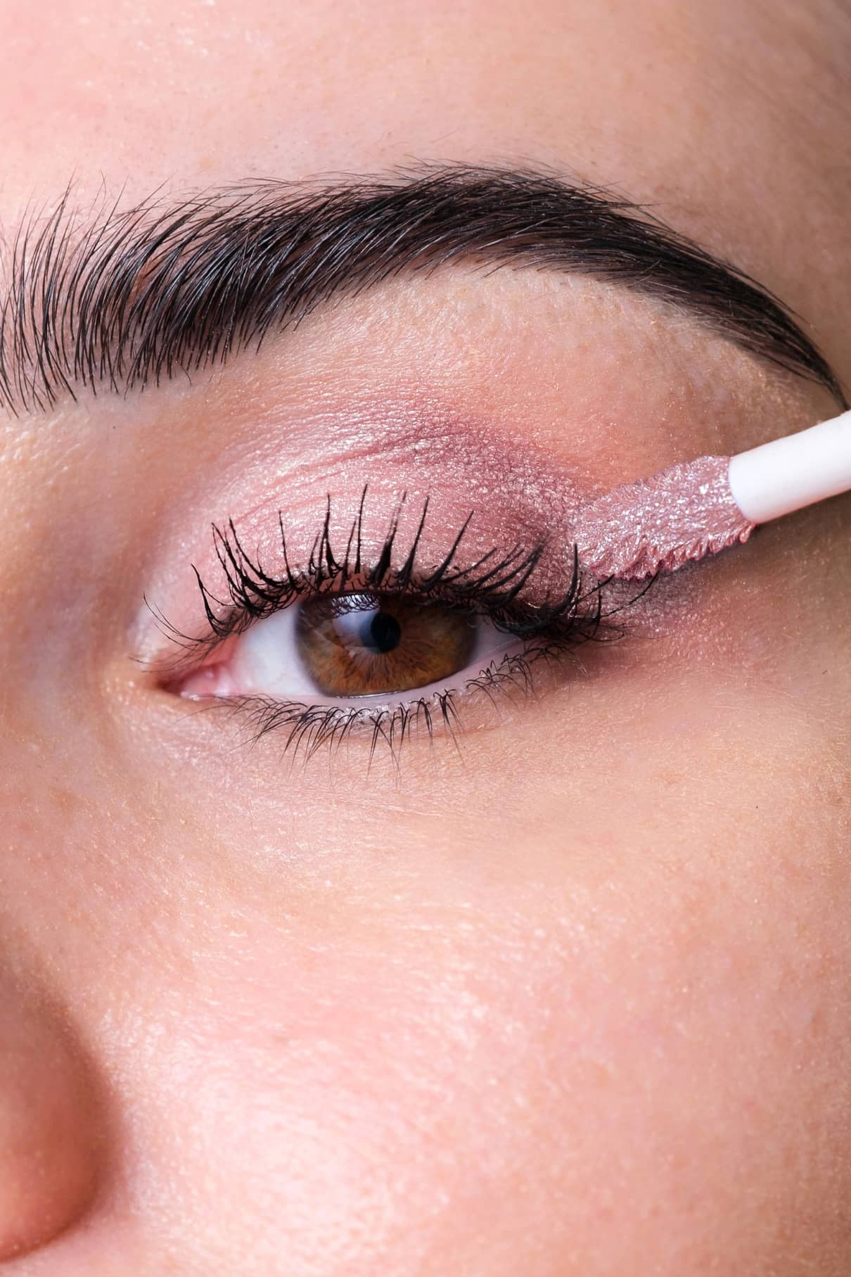 Nahaufnahme einer Person, die Halo Eyes no. 04 Rosé Eyeshadow mit einem Applikator auf ihr Augenlid auf.