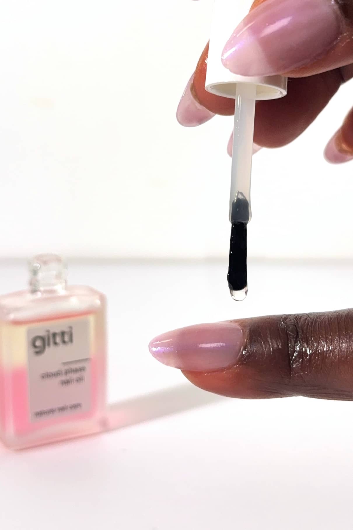 Close up of a dropper dispensing black nail polish onto a fingernail during Pamela's 5min Routine