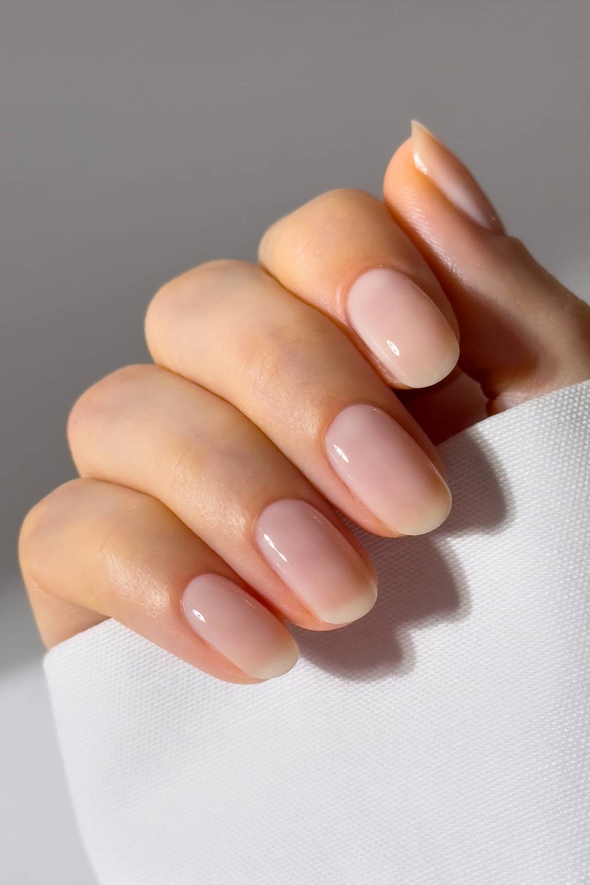 Gepflegte Hand mit natürlichen, glatten Nägeln in zartem Rosé