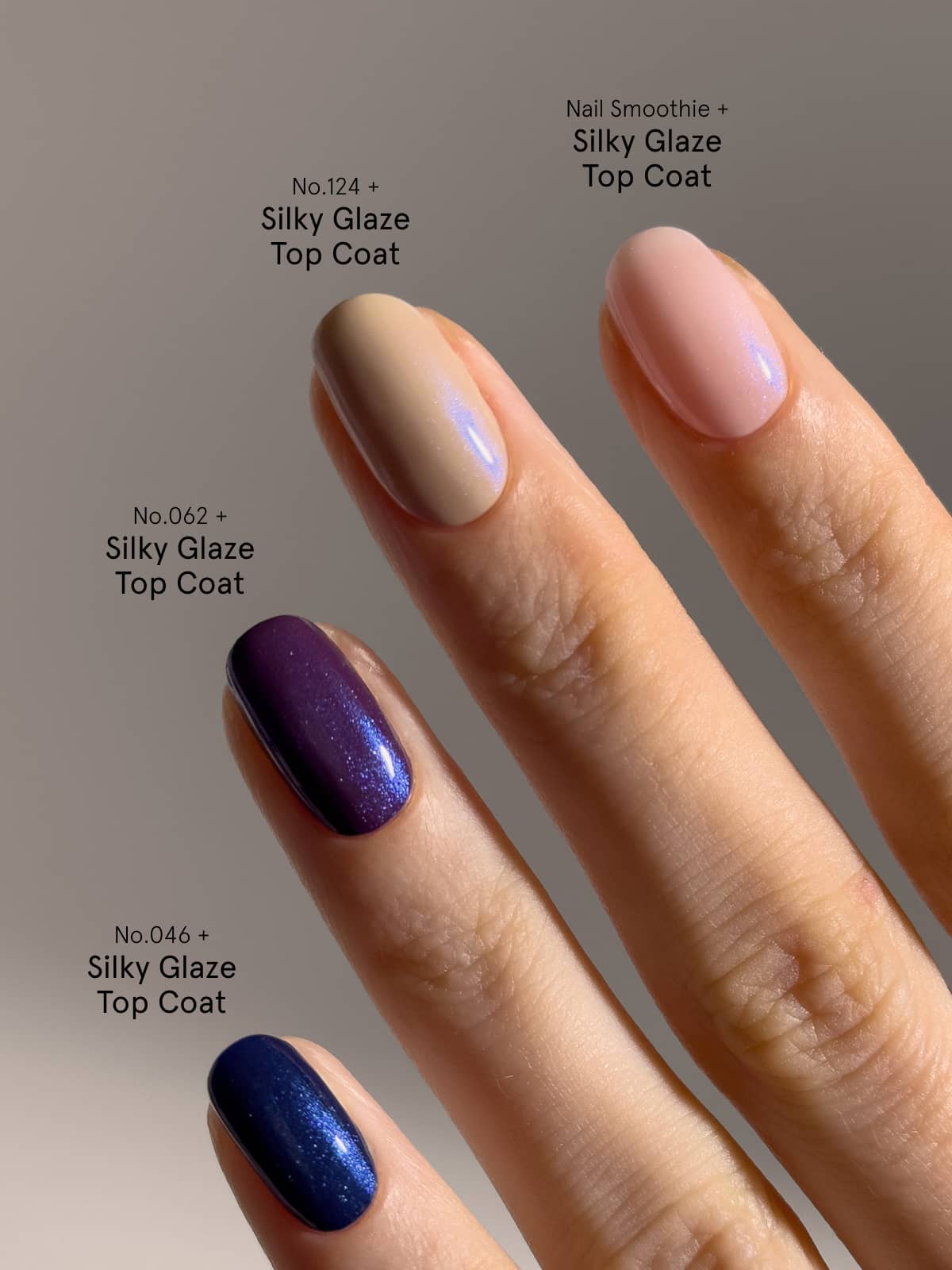 Eine Hand mit vier Fingern, auf denen jeweils ein anderer Nagellackfarbton zu sehen ist, der neben dem „Silky Glaze Top Coat“ mit der entsprechenden Farbnummer beschriftet ist. Die Farben – Nude, Rosa, Dunkelviolett und Blau – präsentieren eine beeindruckende Vielfalt an Finishes, wobei das Blau durch einen faszinierenden blauen Schimmer besticht und so für einen auffälligen Look sorgt. Jeder Finger ist wunderschön mit dem Silky Glaze Top Coat versiegelt, der für zusätzlichen Glanz sorgt.