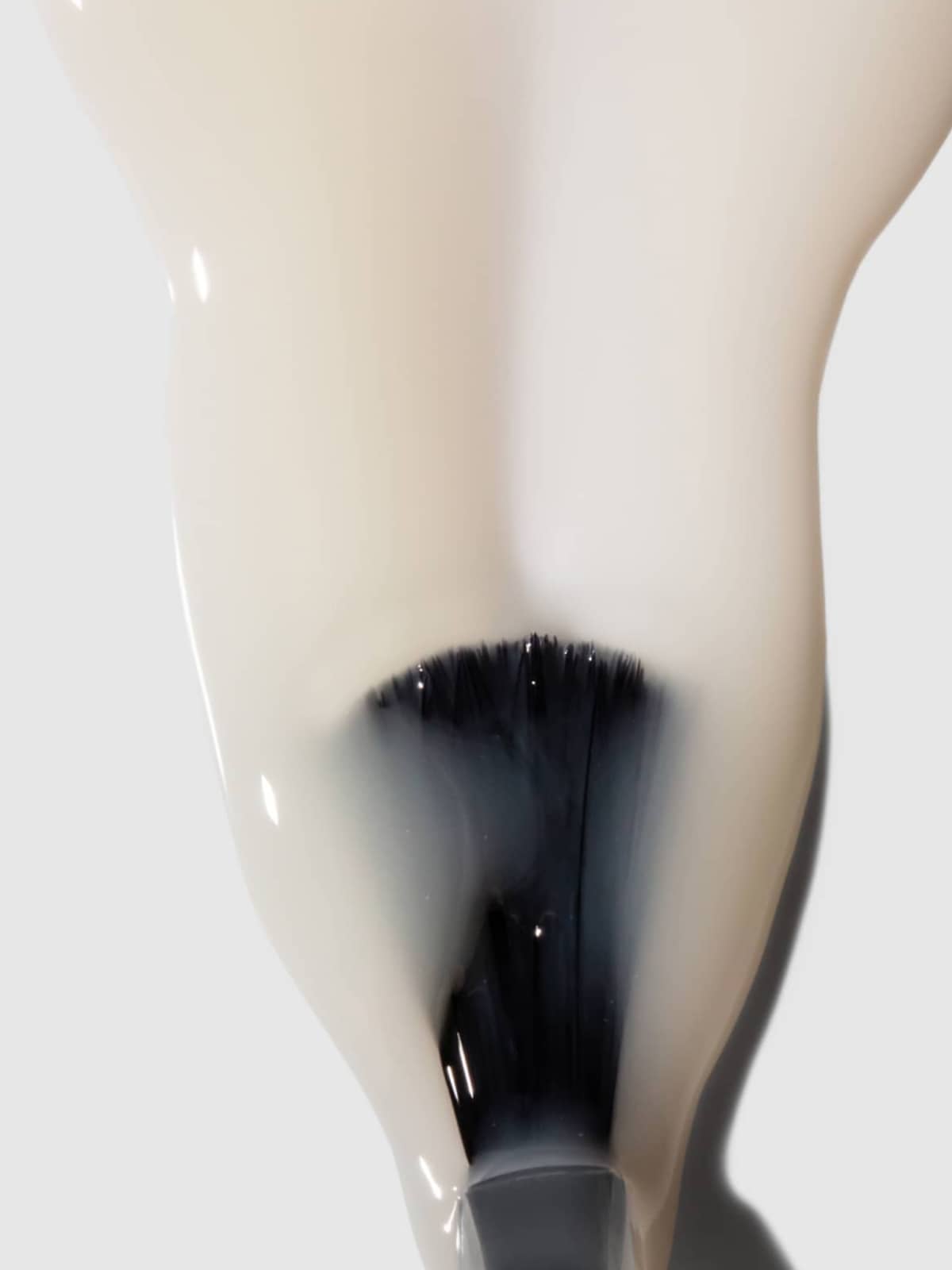 Nahaufnahme eines Pinsels, der mit weißem, wasserbasiertem Nail-Art-Sealer bestrichen ist, wobei die Borsten teilweise sichtbar sind und sich der Sealer auf einer glatten Oberfläche nach außen ausbreitet – ideal, um Ihr Design zu schützen und langanhaltende Ergebnisse zu gewährleisten.