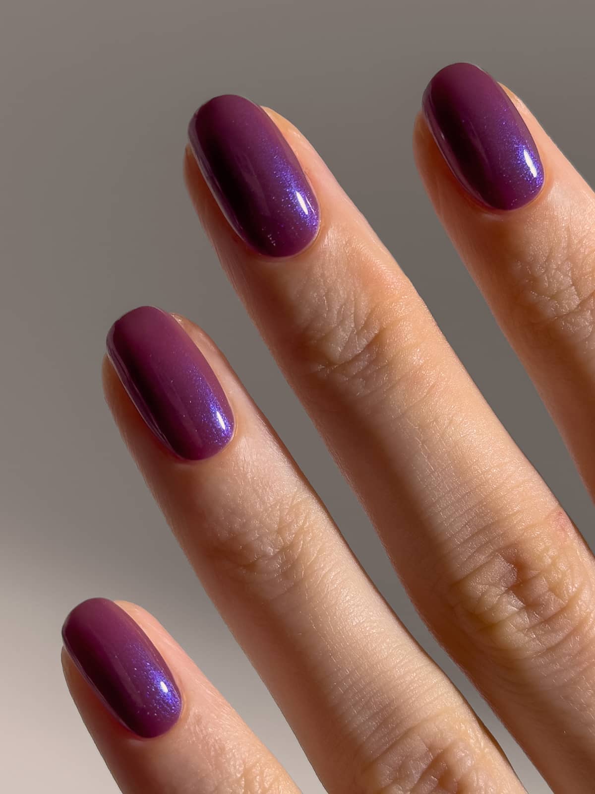 Nahaufnahme einer Hand, auf der vier Finger zu sehen sind, deren sorgfältig gepflegte Nägel alle in dem glänzenden, halbtransparenten Farbton „Pflaumenton“ (Gitti Nr. 063) lackiert sind.