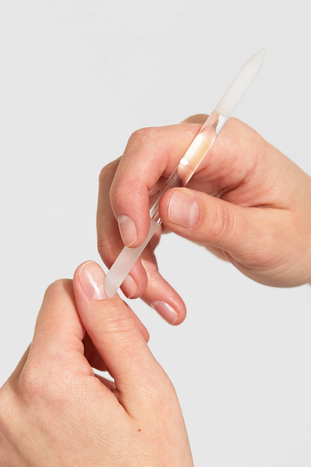 Mit einem Nagelhautschieber aus hochwertigem Glas schiebt man sanft und schonend die Nagelhaut am Daumennagel zurück.