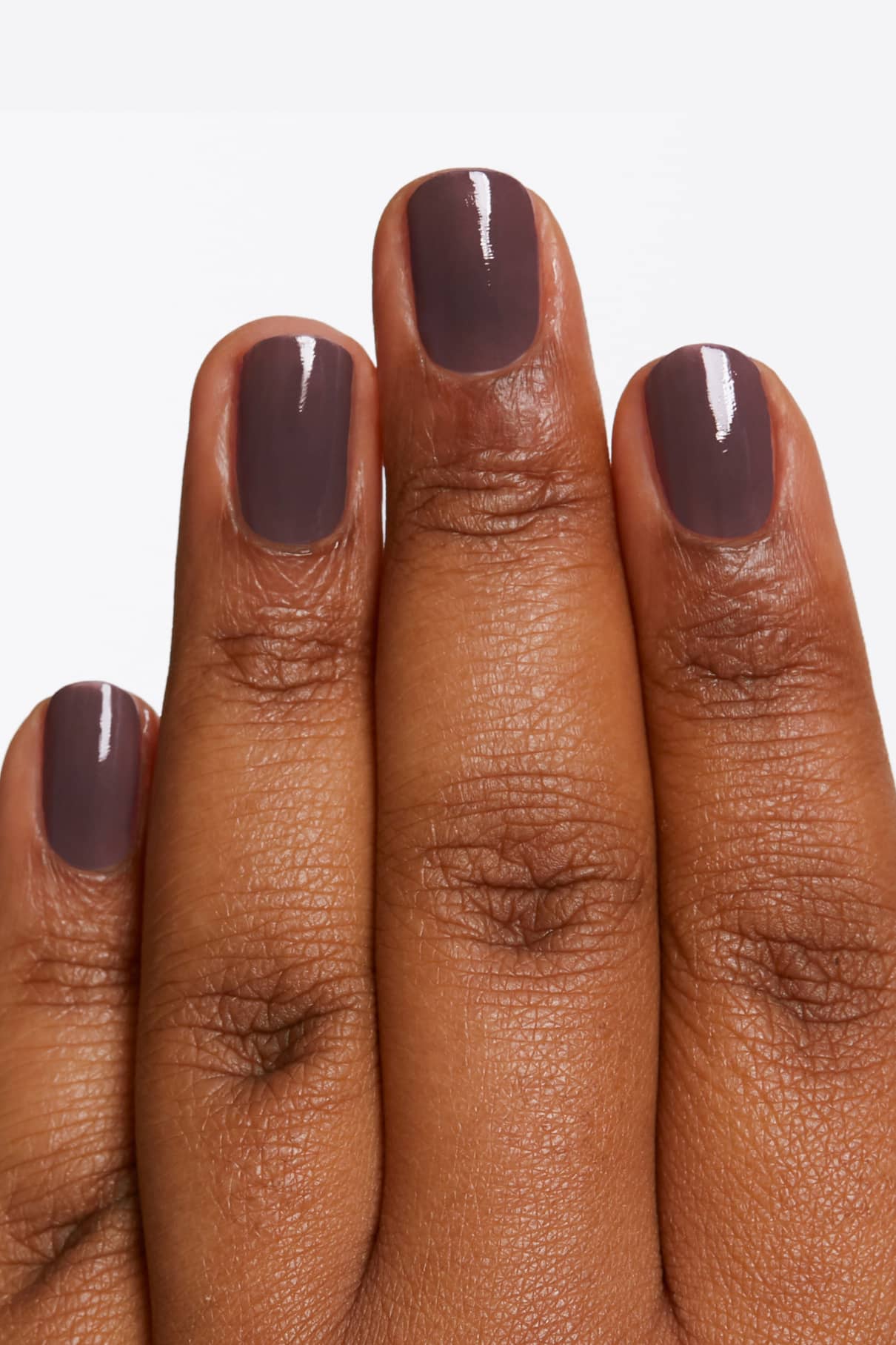 Eine Hand mit mittelbraunem Hautton zeigt sauber manikürte Nägel, die mit gitti no. 116, einem glänzenden mauvefarbenen Nagellack mit violettem Unterton.