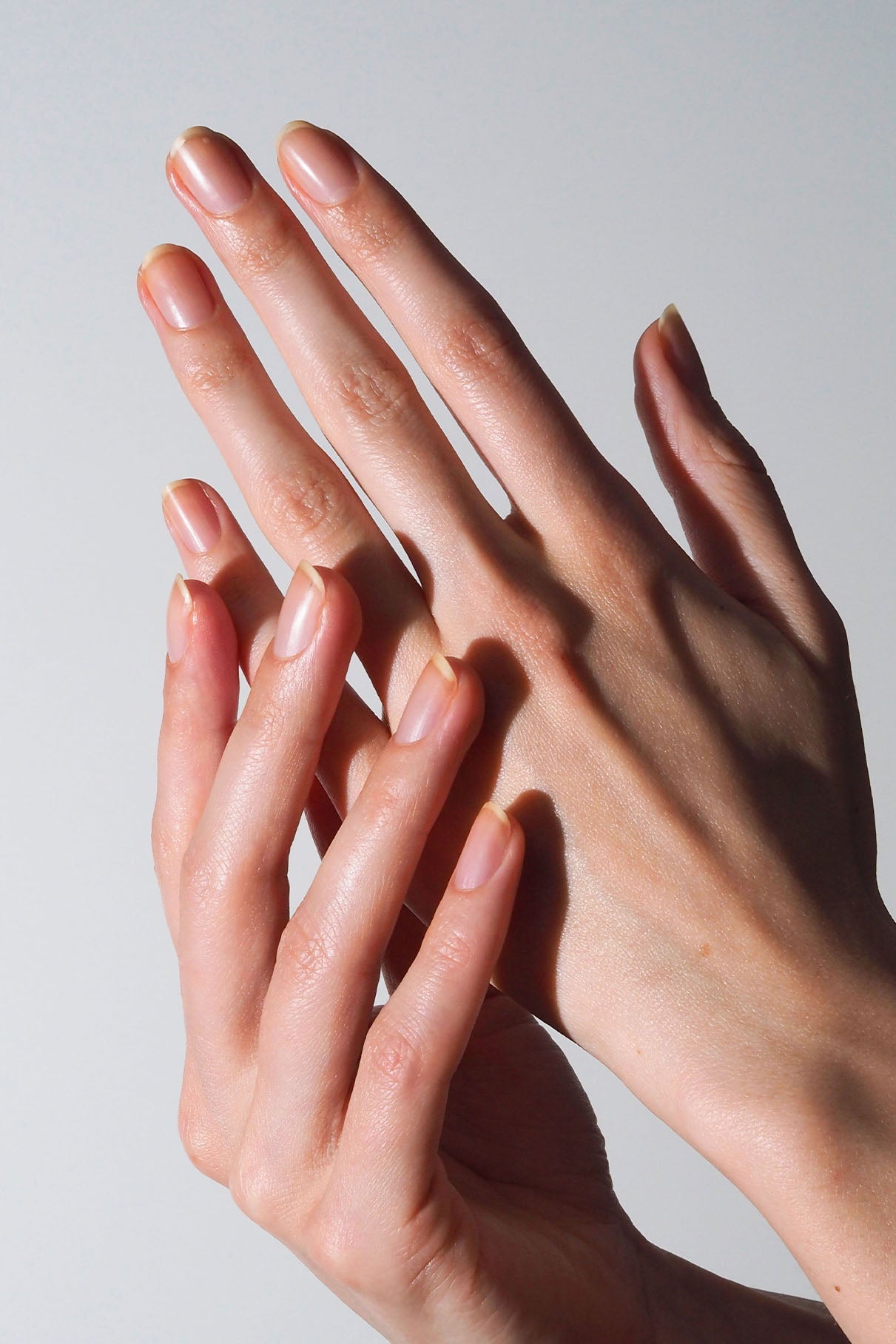 Hands with neatly shaped natural nails to illustrate Nail Recovery Treatment.