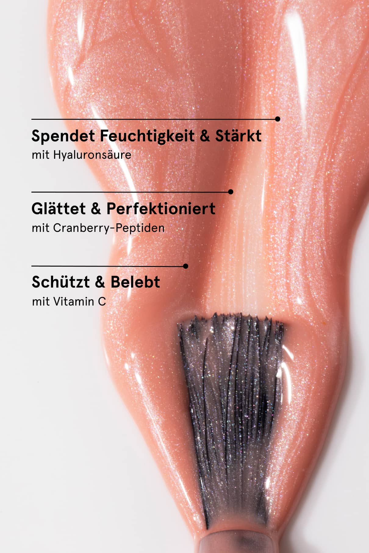 Close-up of a glossy peachy pink nail on a finger displaying Skinified Nail Tint 03.