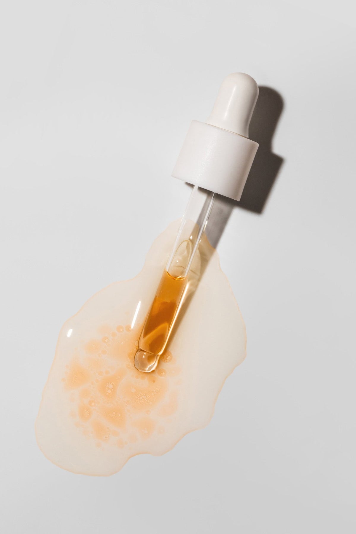 Nail recovery dropper with pale amber oil on a light background