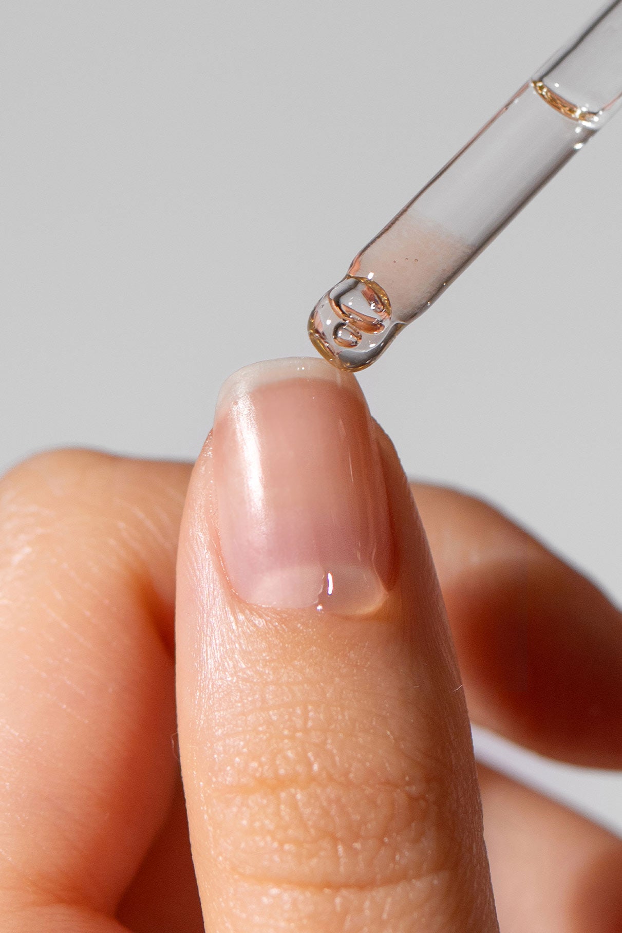 Eine Pipette trägt das pflegende Nagelöl von Be A Softie auf den Fingernagel auf und bereichert jedes Nagelpflegeset.