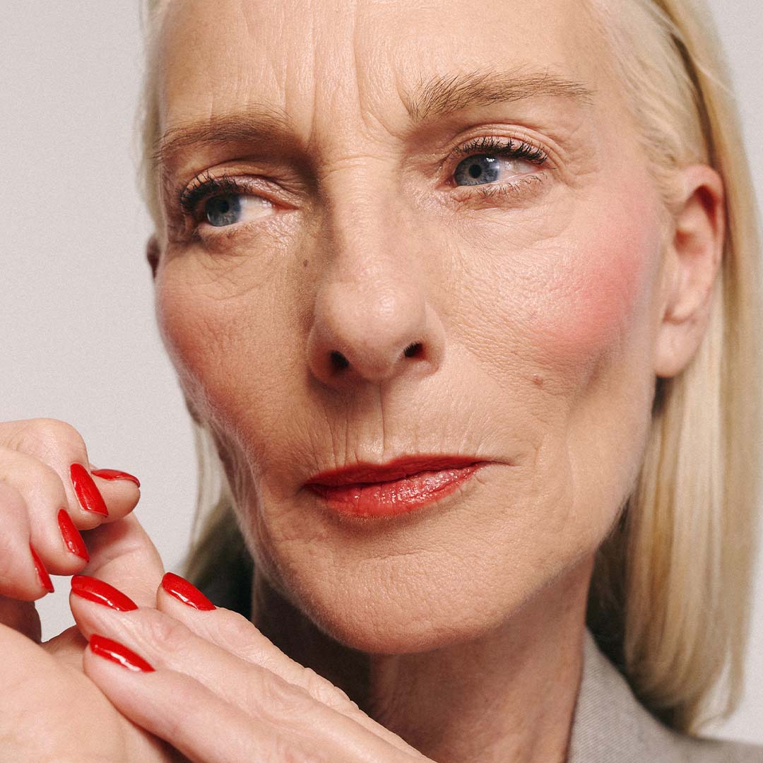 Model trägt Full gitti Makeup Look und roten Nagellack