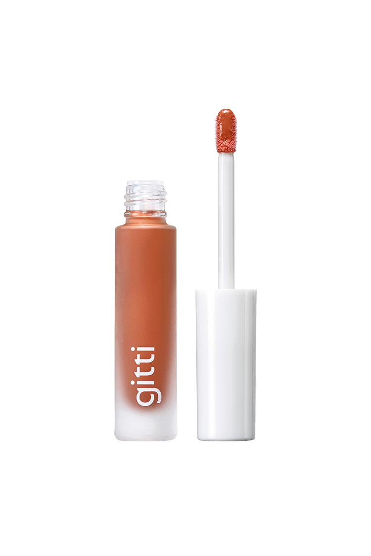Eine Tube Lip Glaze no. 04 mit abgenommener Kappe und Applikatorstab zeigt einen warmen Braunton mit einem hochglänzenden Finish für einen strahlenden Look.