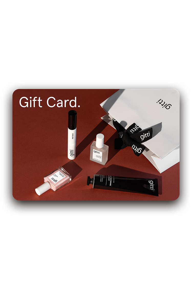 Ein Digitaler Geschenkgutschein und vier minimalistische Kosmetikprodukte sind auf einer dunkelroten Fläche neben einer weißen Geschenkbox mit schwarzer Schleife angeordnet.