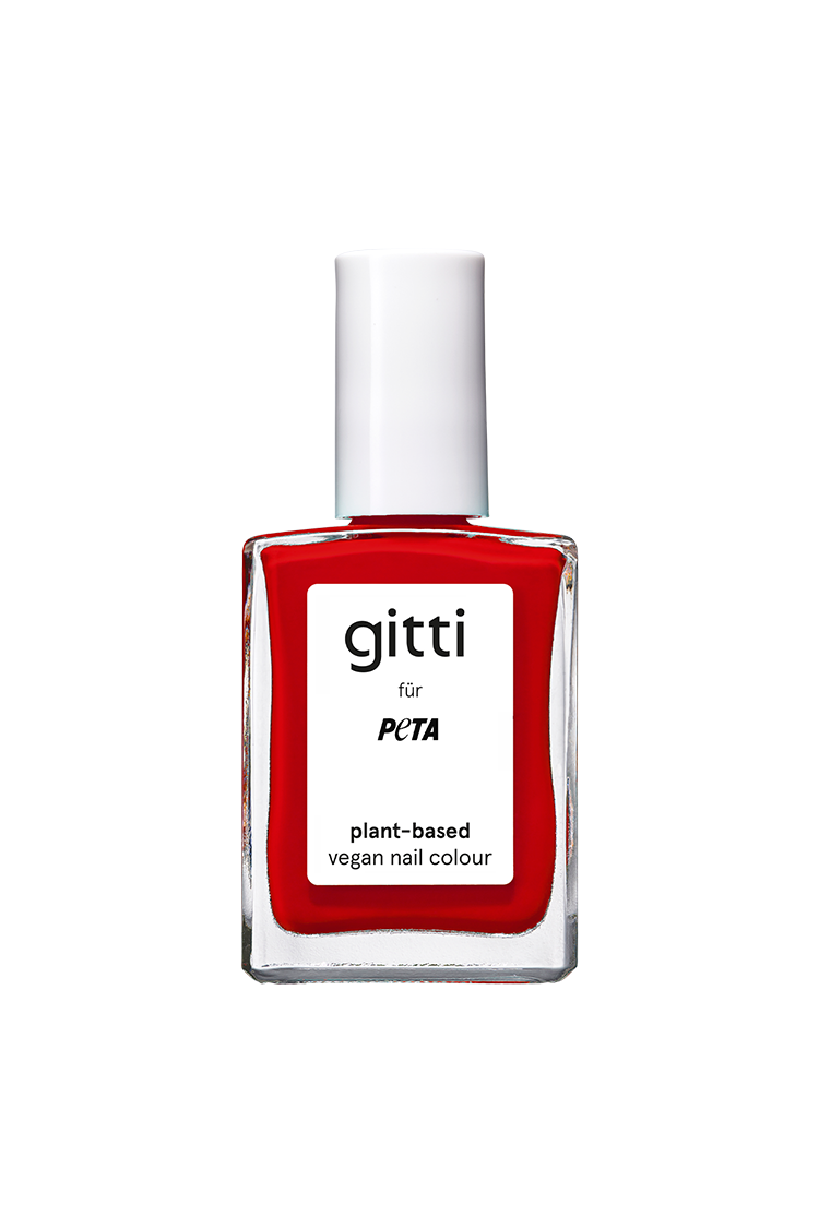 Eine Flasche pflanzlicher, veganer Nagellack von „gitti x PETA“ in einem leuchtenden Rotton mit orangefarbenen Untertönen und weißem Verschluss, vor einem schlichten, hellen Hintergrund.