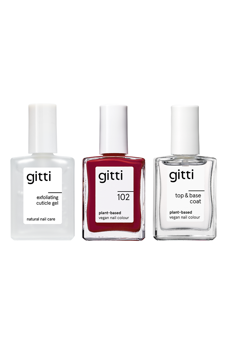 Das Essential Manicure Set enthält drei aufrecht stehende Flaschen mit eleganten weißen Kappen: Peeling-Häutchen-Gel, vegane Nagelfarbe auf Pflanzenbasis im Farbton 102 und einen Top & Base Coat.