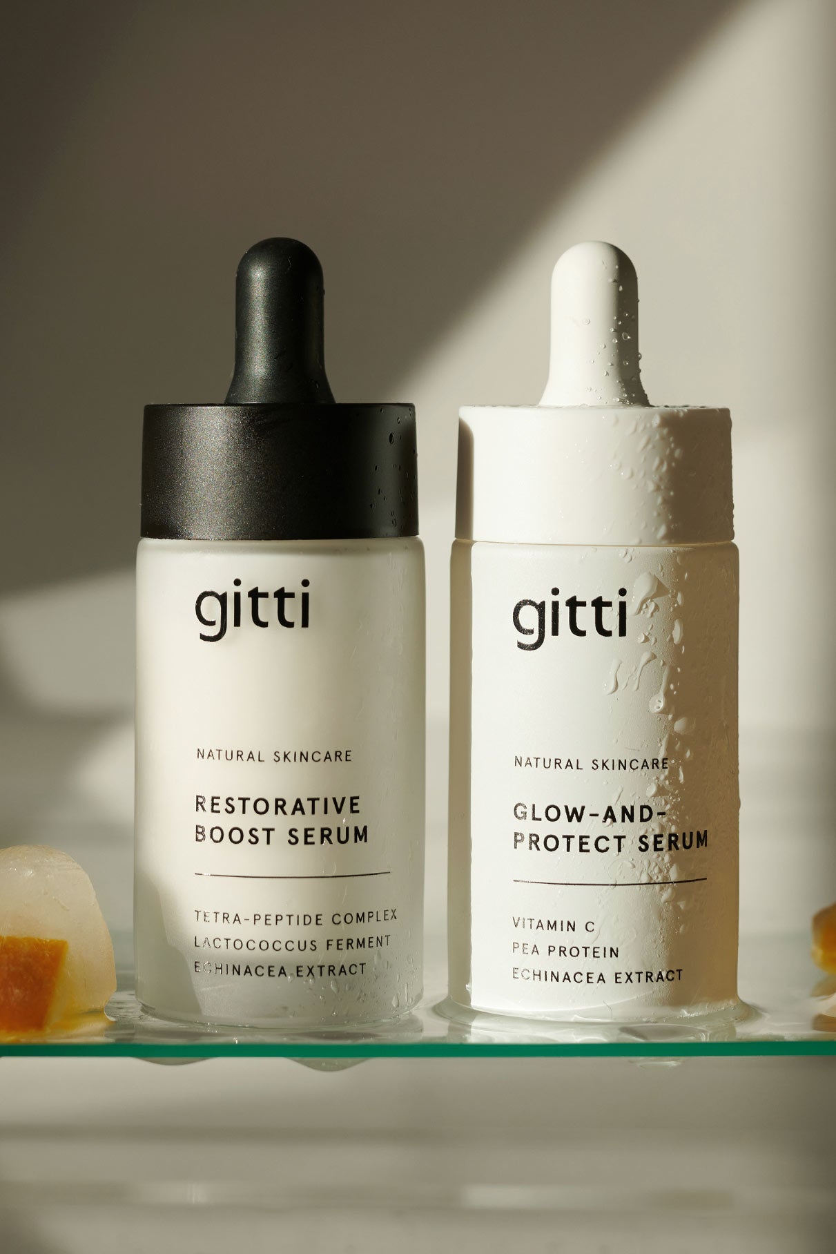 Das Serum-Duo, bestehend aus dem gitti natural Restorative Boost Serum und dem Glow-and-Protect Serum, liegt nebeneinander auf einer leichten Unterlage - das perfekte Set für jedes Pflegebedürfnis.