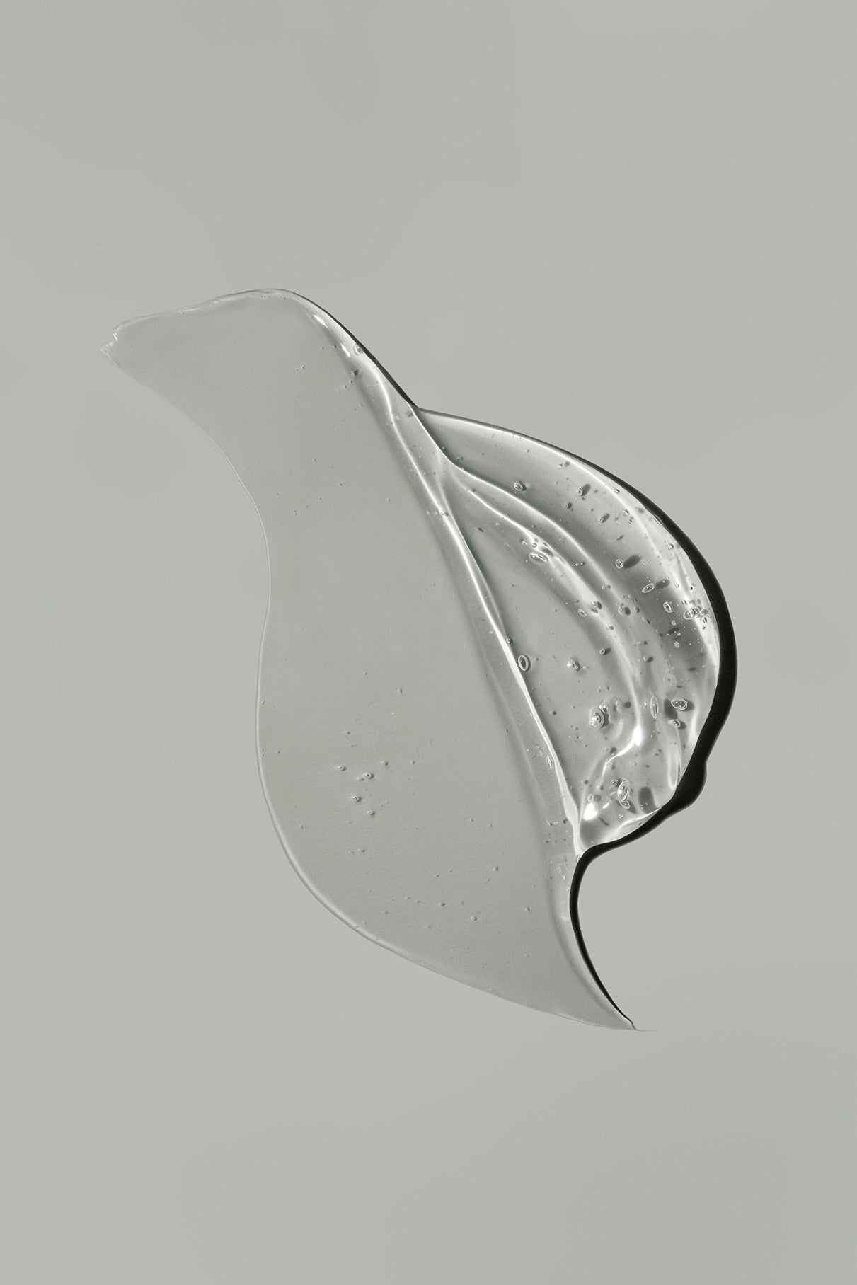 Sanftes Gen C Gel mit kleinen Bläschen, geschwungen auf hellgrauem Hintergrund - inspiriert von der effektiven Reinigung eines Öl-Cleansers.