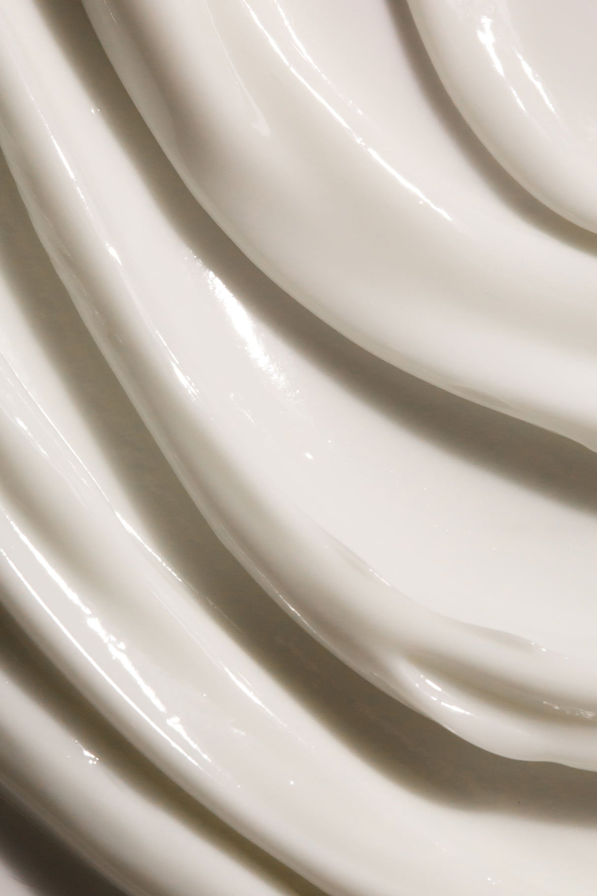 Nahaufnahme von Skin Rhythm Moisturiser Rich: glatte, weiße Creme mit dicken, glänzenden Wellen und strukturierten Rillen, die intensive Feuchtigkeit spendet und für ein gesundes Strahlen sorgt.